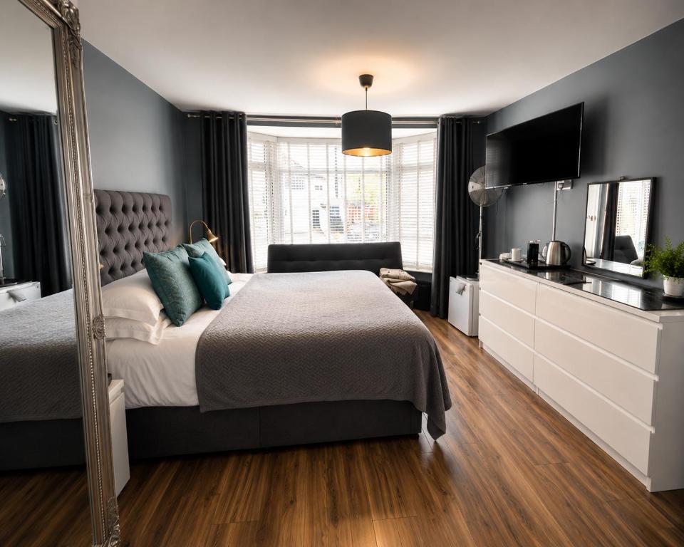 a bedroom with a large bed and a mirror at Skyline Guesthouse Newquay in Newquay