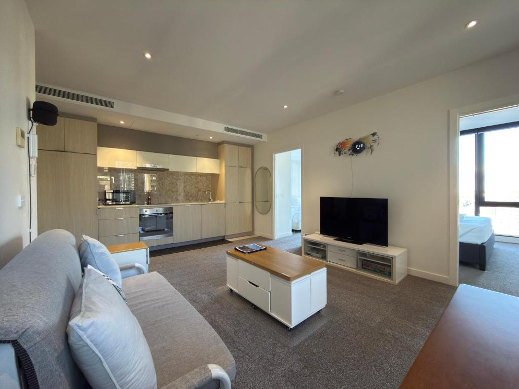 a living room with a couch and a tv at Southbank Sanctum in Melbourne