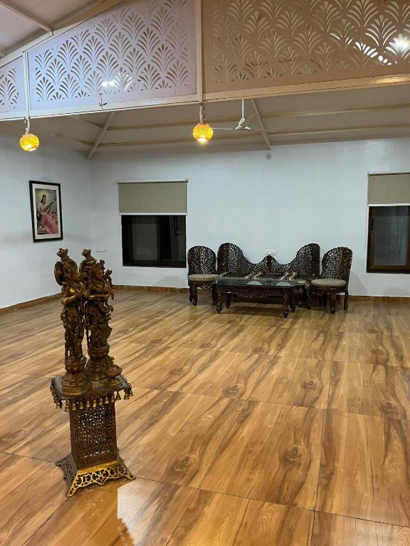 a room with a row of chairs and a wooden floor at Kanakdhara farmhouse in Ujjain