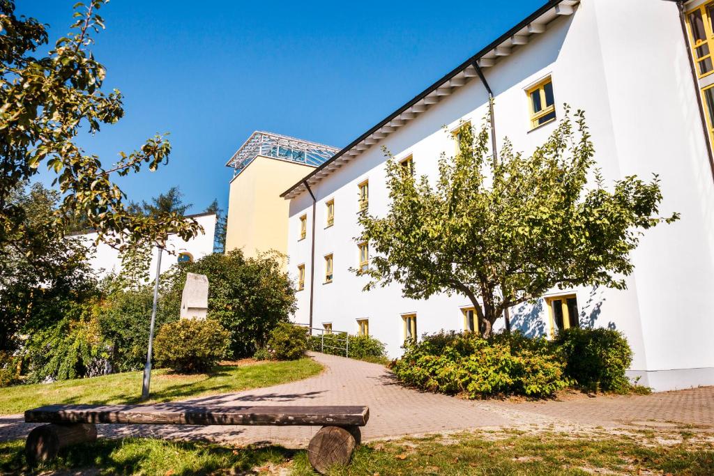 a bench in front of a white building at Jugendherberge Wunsiedel in Wunsiedel