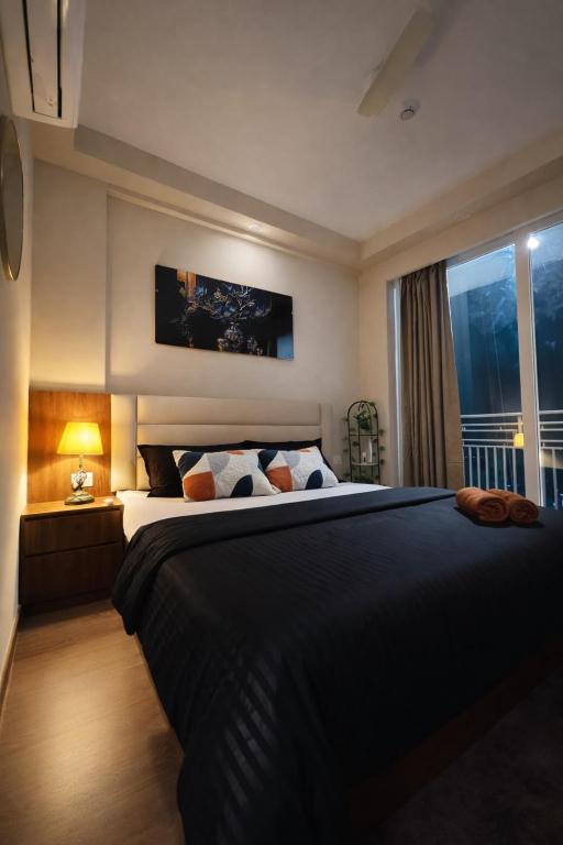 a bedroom with a large bed and a window at Cozy Corner in Greater Noida