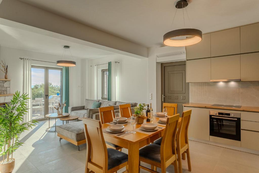 a kitchen and living room with a wooden table and chairs at Sofia's Villa in Riglia
