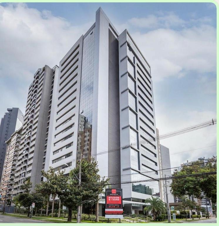 a tall white building in the middle of a city at THE ONE - Flat Batel Premium in Curitiba