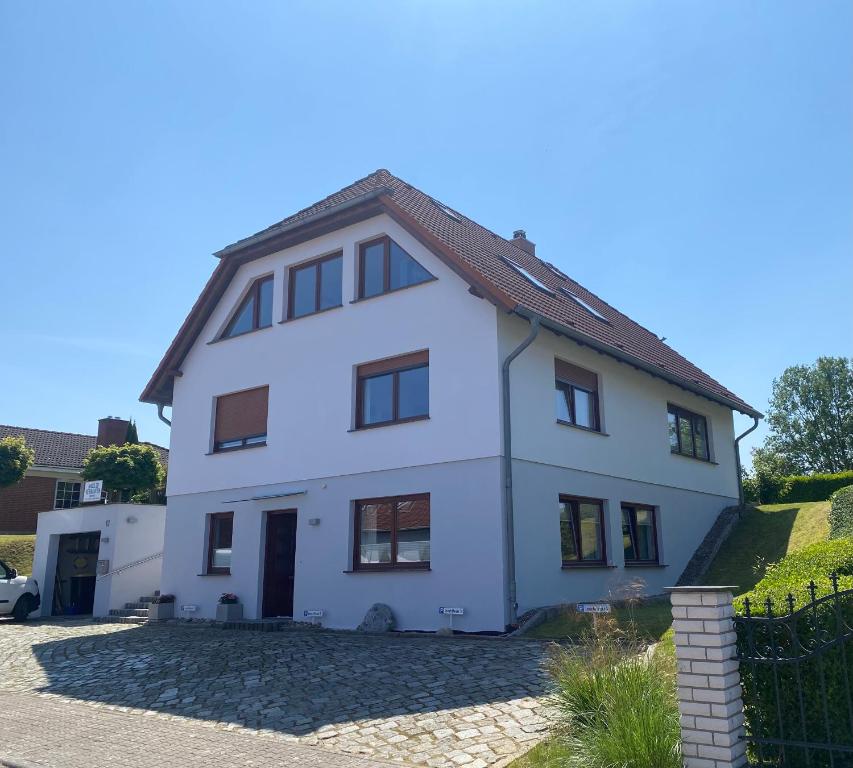 a white house with a brown roof at Ferienwohnungen Arkonablick in Lohme