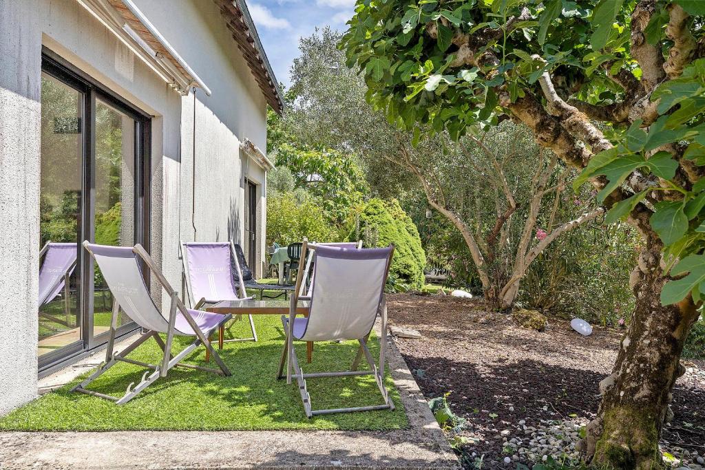 a group of chairs and a table in a yard at Gîte La Loge in Saint-Aignan