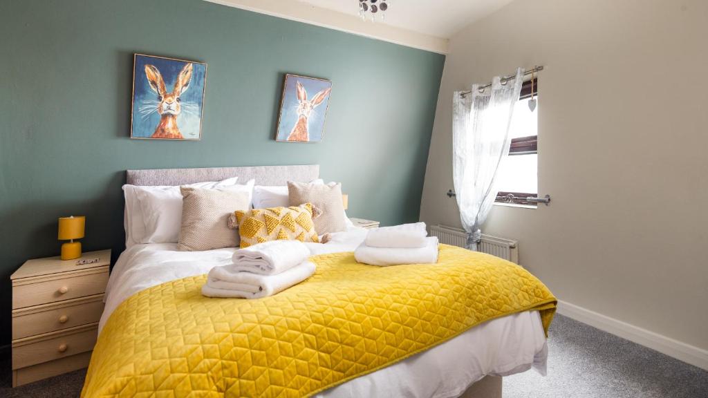 a bedroom with a yellow bed with towels on it at The Granby Hotel in Whitby