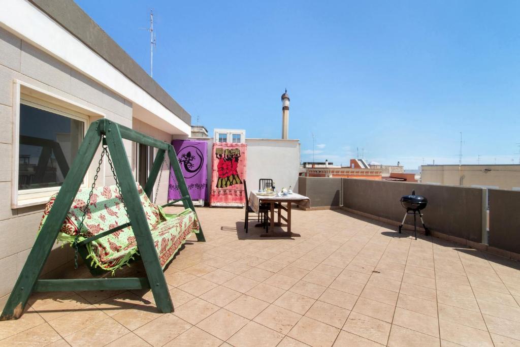 a patio with a swing and a table on a roof at La Mansarda - Terrazze Relax A Due in Cellamare