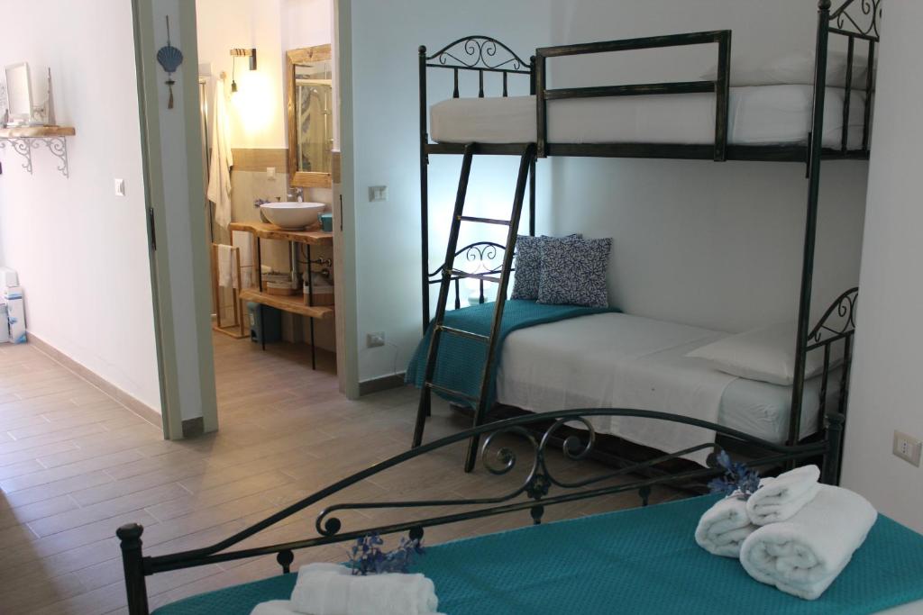 a bedroom with two bunk beds and a bathroom at Casa Briseida in Baia Verde