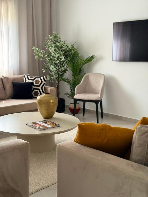 a living room with a couch and a table and chairs at NYC trifft auf Top Moderne Wohnung in Hergla in Harqalah
