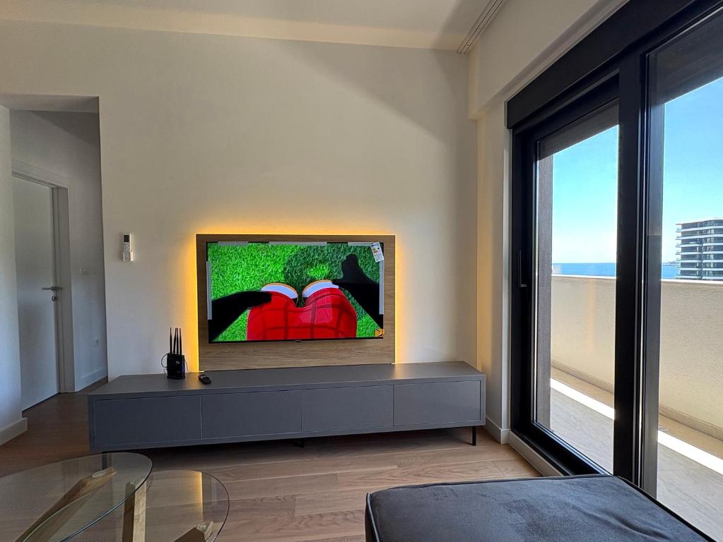 a living room with a tv and a glass table at Luxury 2BR Sea View & Garage & Twin Towers Becici in Bečići