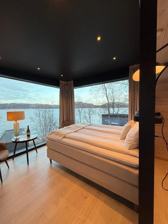 a bedroom with a large bed and a large window at Aurora Sea Lodges in Karpbukt
