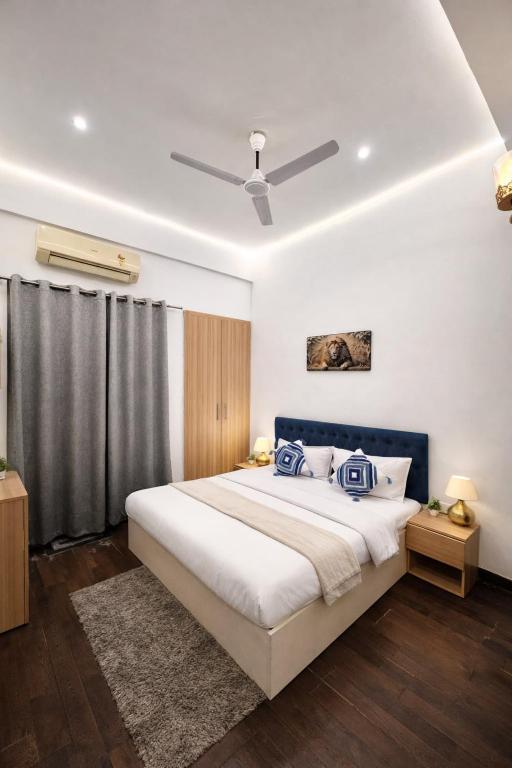 a bedroom with a large bed with a ceiling fan at Glory Stays in Noida