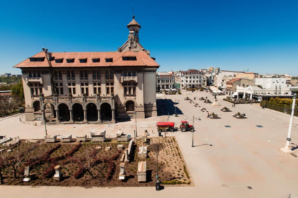 a building with a tower on top of a street at Dor de Mare - Piata Ovidiu Constanta in Constanţa