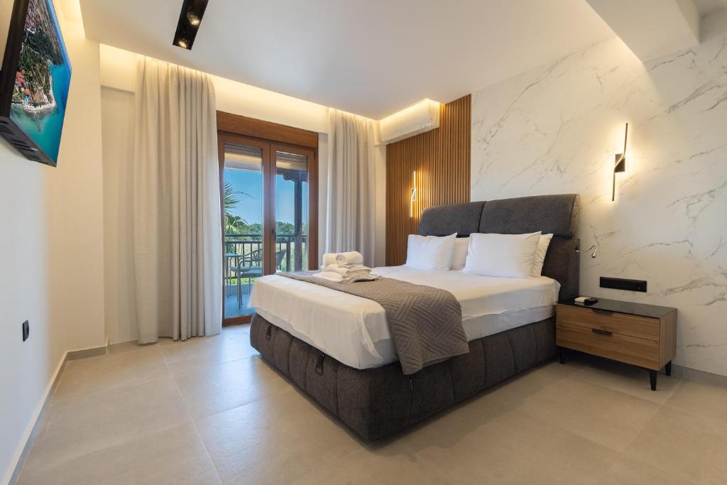 a bedroom with a large bed and a balcony at Afitos Luxury Villas in Afitos