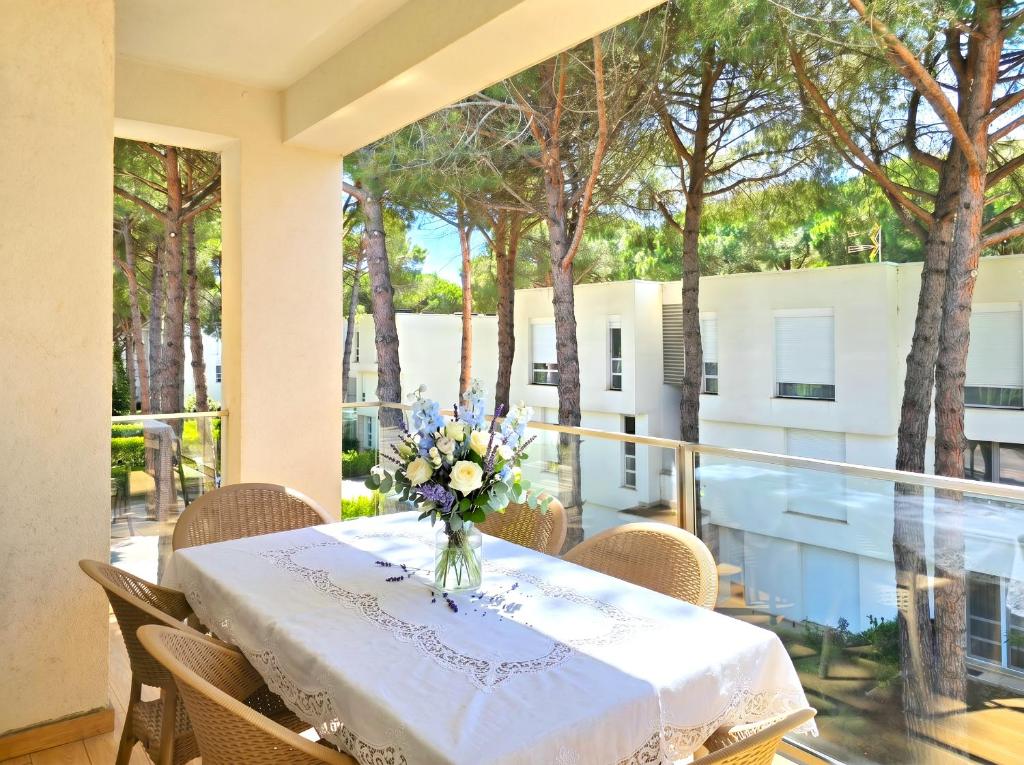 a table with a vase of flowers on a balcony at White Shell Apartments in Lalzit Bay