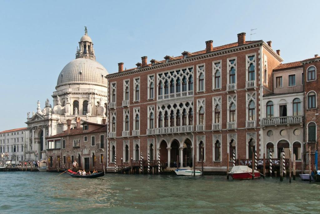 Blick auf einen Kanal mit einem Gebäude und einer Kuppel in der Unterkunft Sina Centurion Palace in Venedig