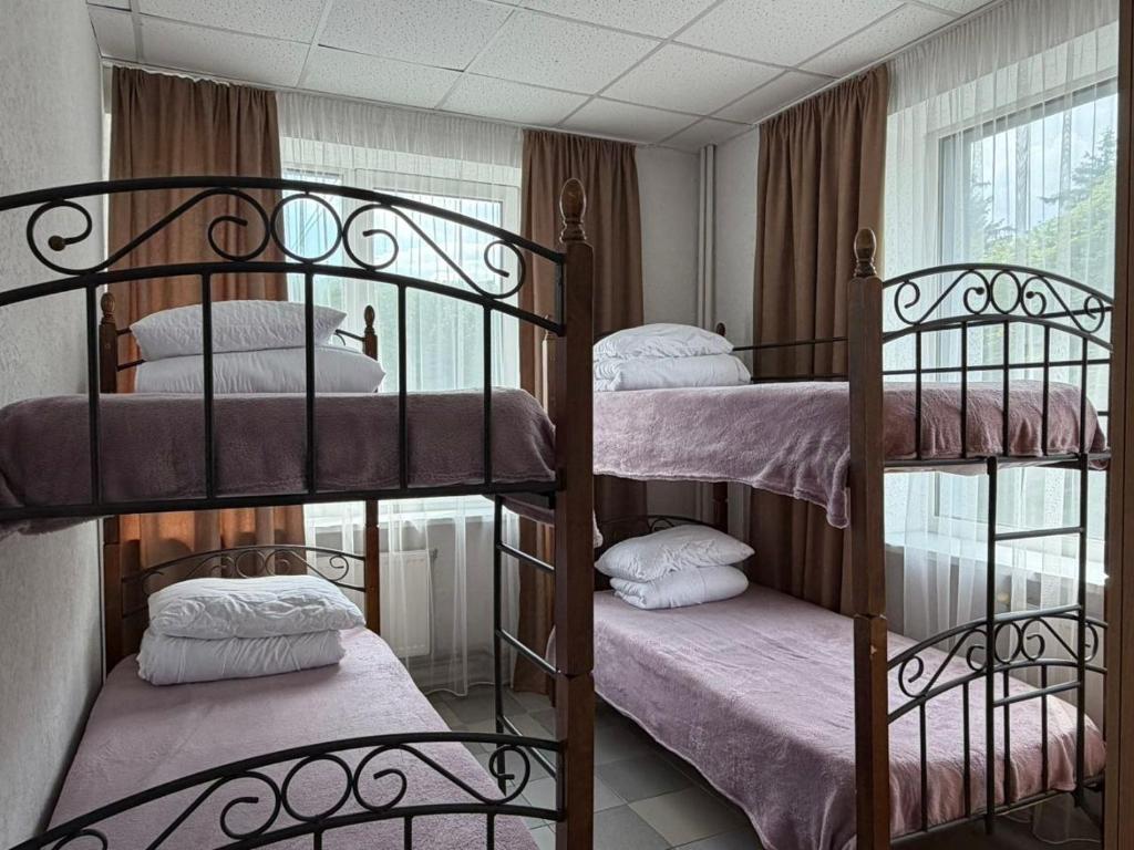 a room with three bunk beds with pink sheets at Хостел Арабея in Vinnytsya