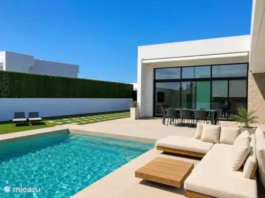 a swimming pool with a white couch and a table at Casa Calma in Calasparra