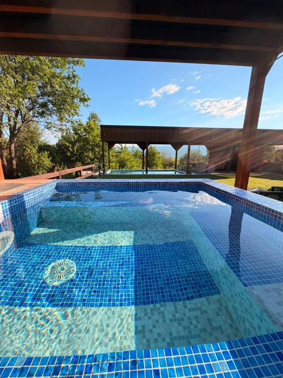a pool with a blue tile floor and a pavilion at Hellena 2 in Sarajevo