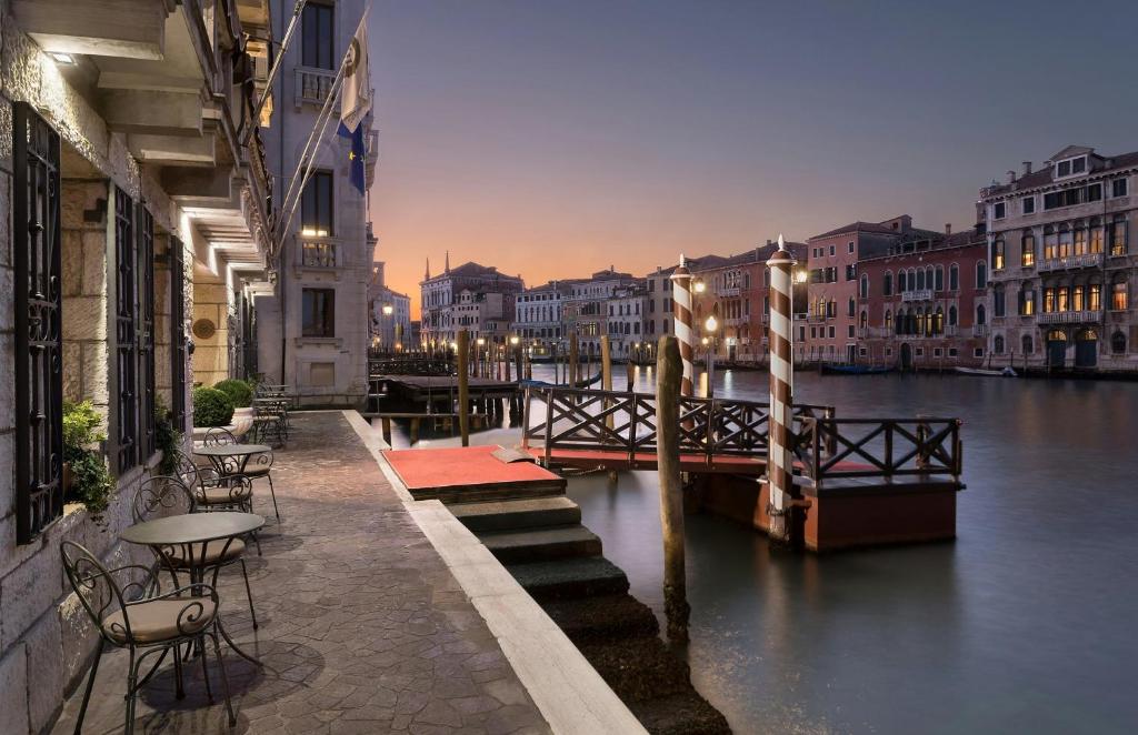 a view of a canal with tables and chairs on a bridge at Sina Palazzo Sant'Angelo in Venice