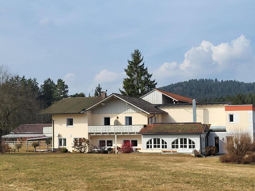 a large white house with a large yard at Landhaus Auhirsch in Böbrach