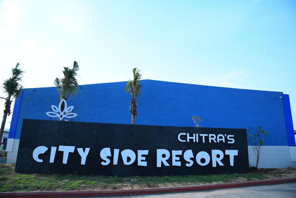 a city side resort sign in front of a building at Chitra's City Side Resort in Solapur