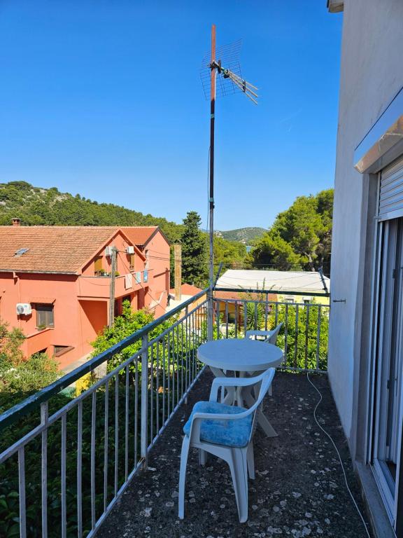 a patio with a table and a chair on a balcony at Rooms LuaMar in Sali
