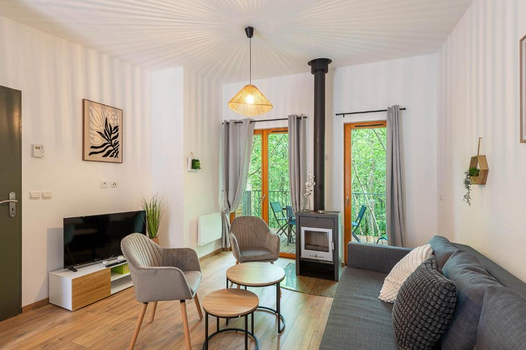 a living room with a couch and a tv at Les Charmes C15 - Le Val Joly in Eppe-Sauvage