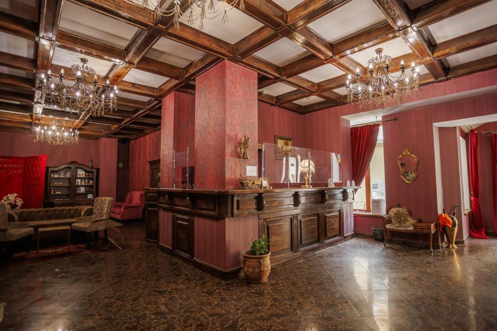 a large room with red walls and chandeliers at City Center Residence in Chernivtsi