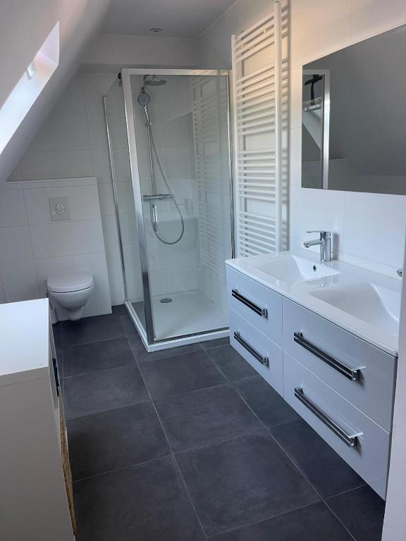a white bathroom with a shower and a sink at Chambre privée proche centre ville in Caen