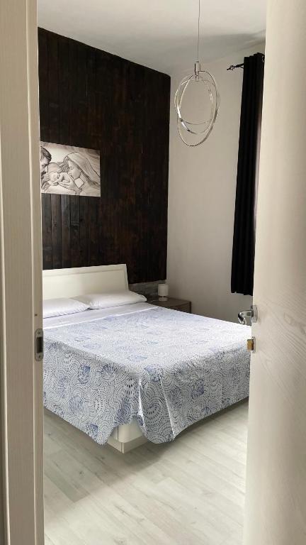 a bedroom with a bed with a blue and white blanket at Camera in centro storico in Olbia