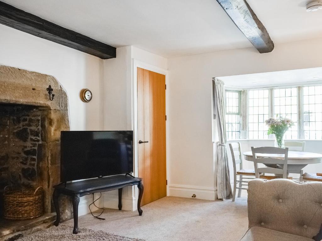 a living room with a tv and a fireplace at Causeway Cottage in Wolsingham