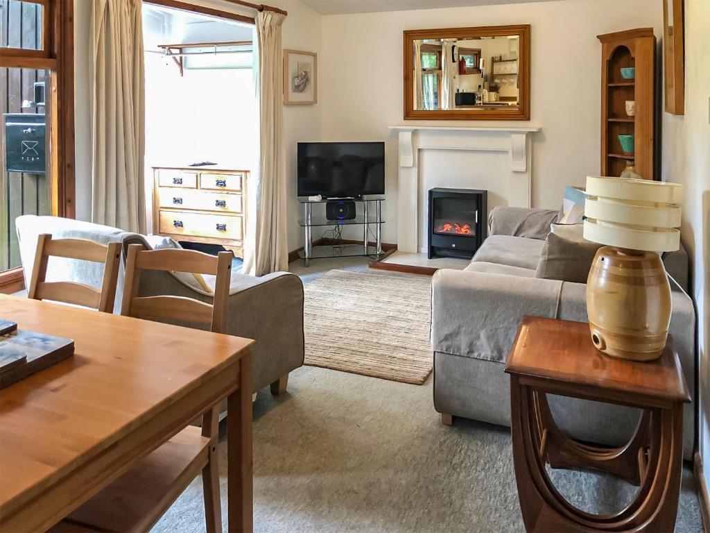 a living room with a couch and a fire place at The Lodge in Uny Lelant