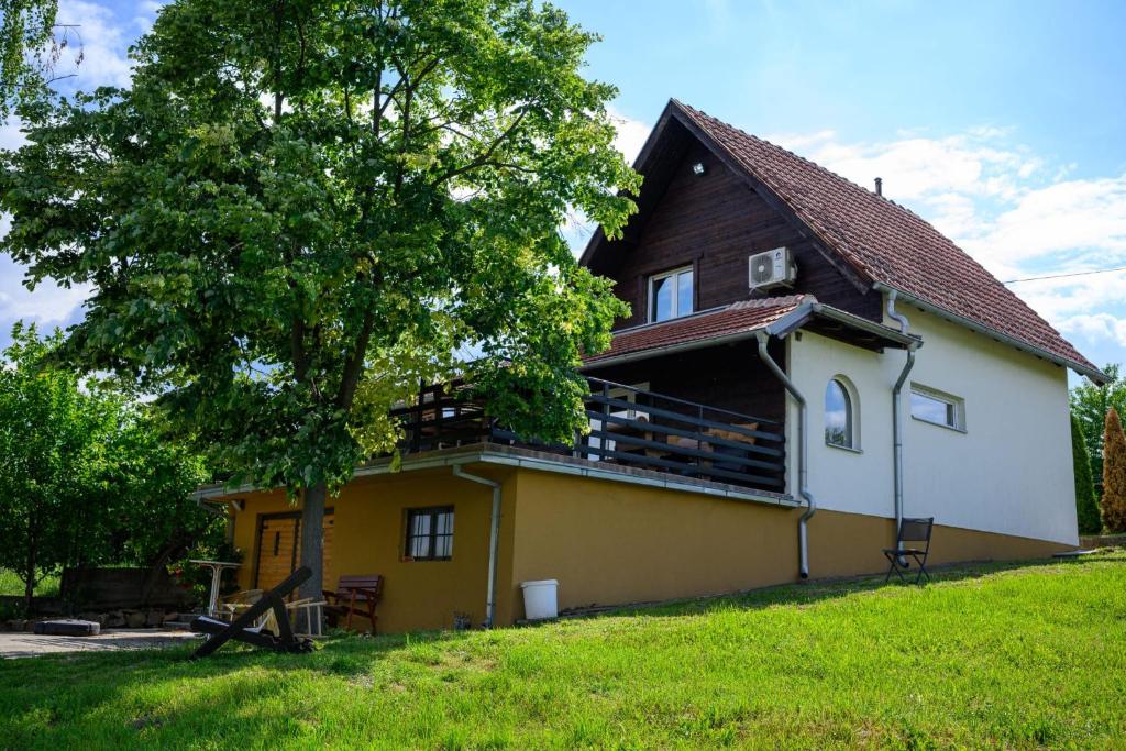 a yellow and white house with a tree at Kuća Sokolovića in Zaječar