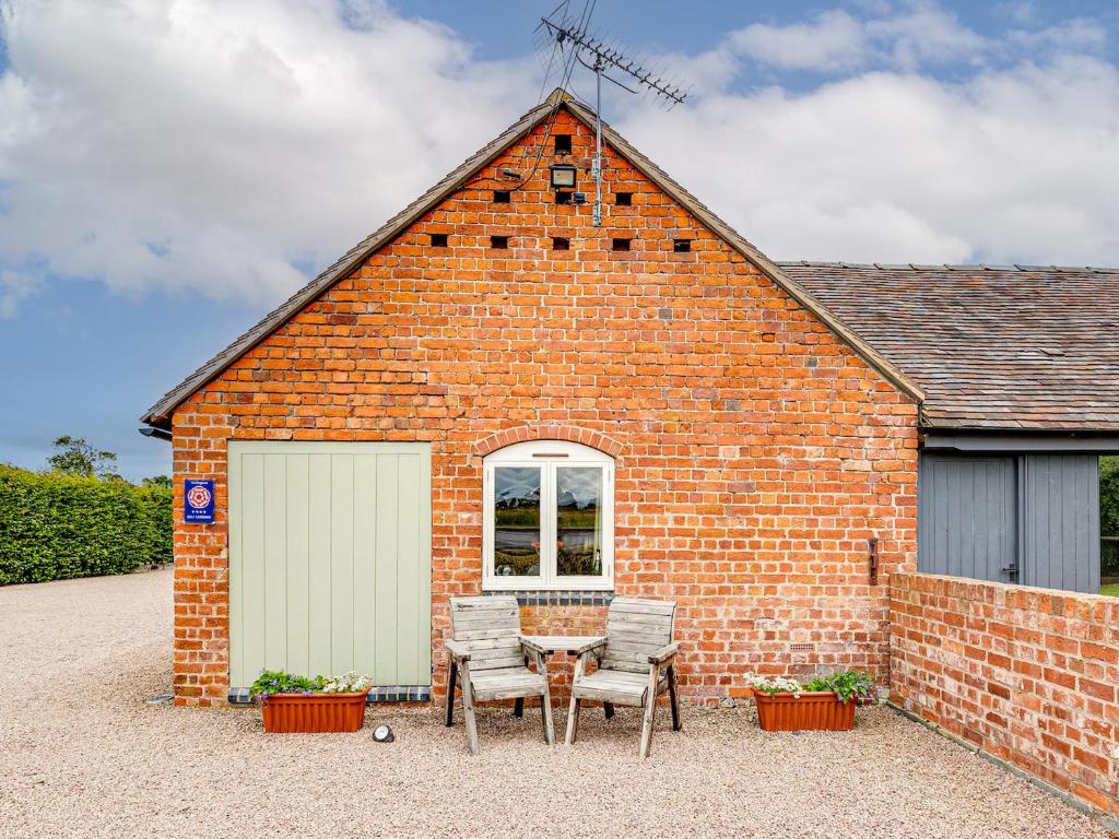 a brick building with a table and chairs in front of it at The Dairy - Uk10957 in Burlton