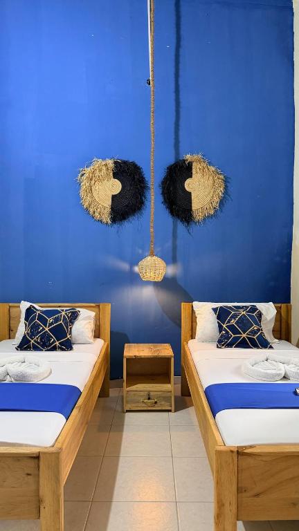 two beds in a room with a blue wall at Golden Nap hostel in Zanzibar City