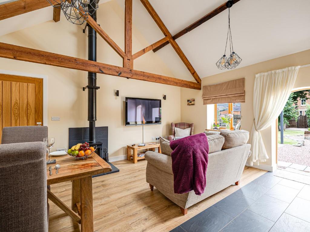 a living room with a couch and a table at The Parlour - Uk10958 in Burlton