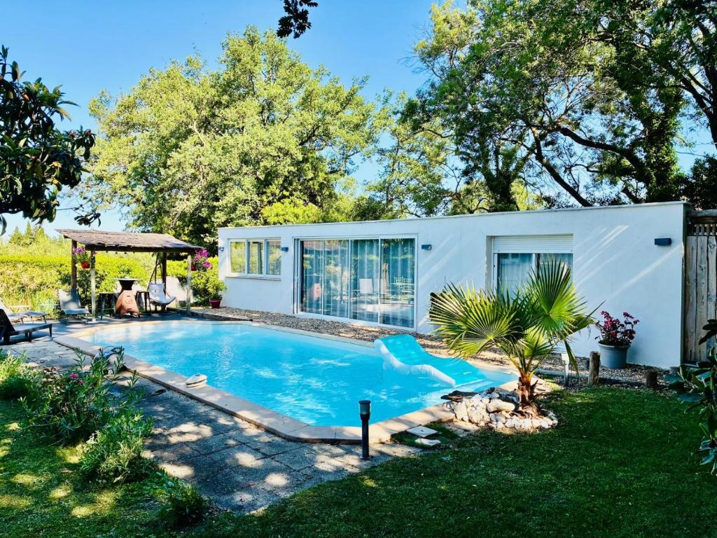 a house with a swimming pool in a yard at Échappée Mistral - Jacuzzi Privé & Brasero in Eyragues