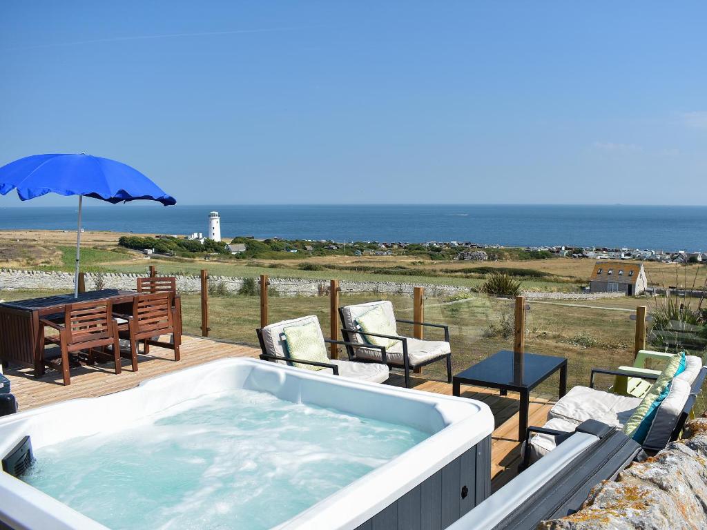 a hot tub on a deck with a table and chairs at Lloyds Cottage in Southwell