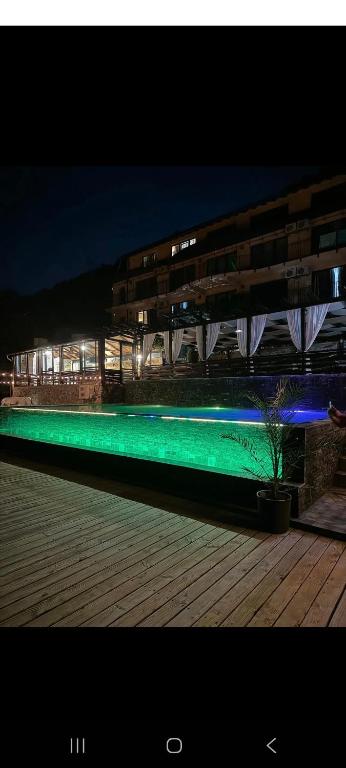 a swimming pool with green illumination in front of a building at Casa Aless Eselnita Adults Only 14 plus in Eşelniţa