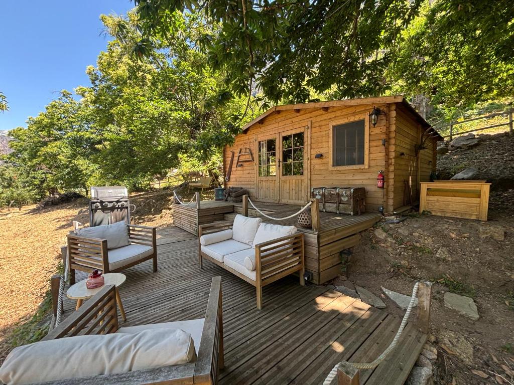 a wooden deck with chairs and a cabin at Chalet studio in Porto Ota