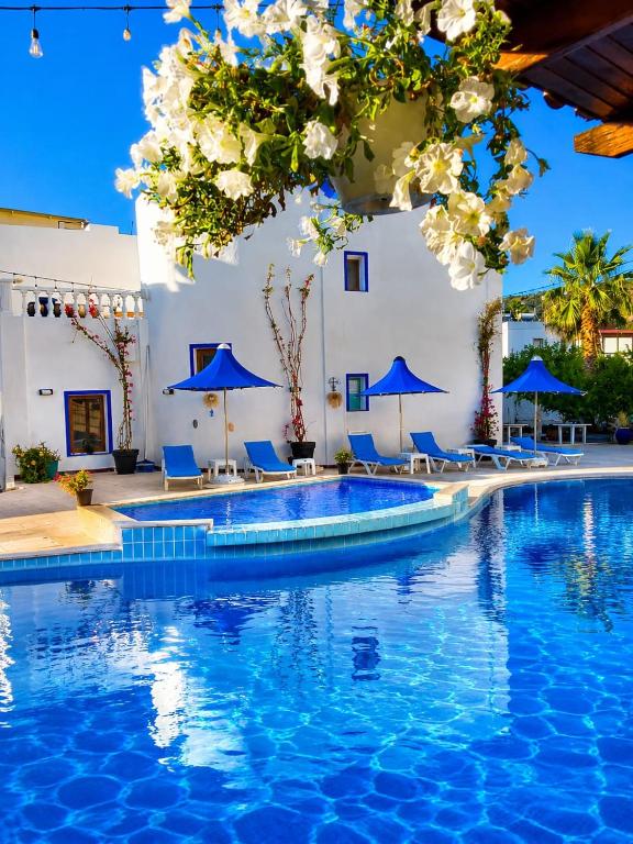a pool with blue chairs and blue umbrellas at Bodrum Blu Hotel in Bodrum City