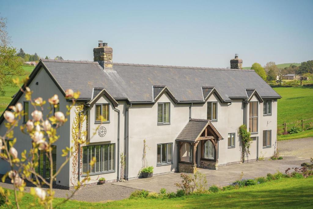 a white house with a black roof at Ceunant in Llanfair Caereinion