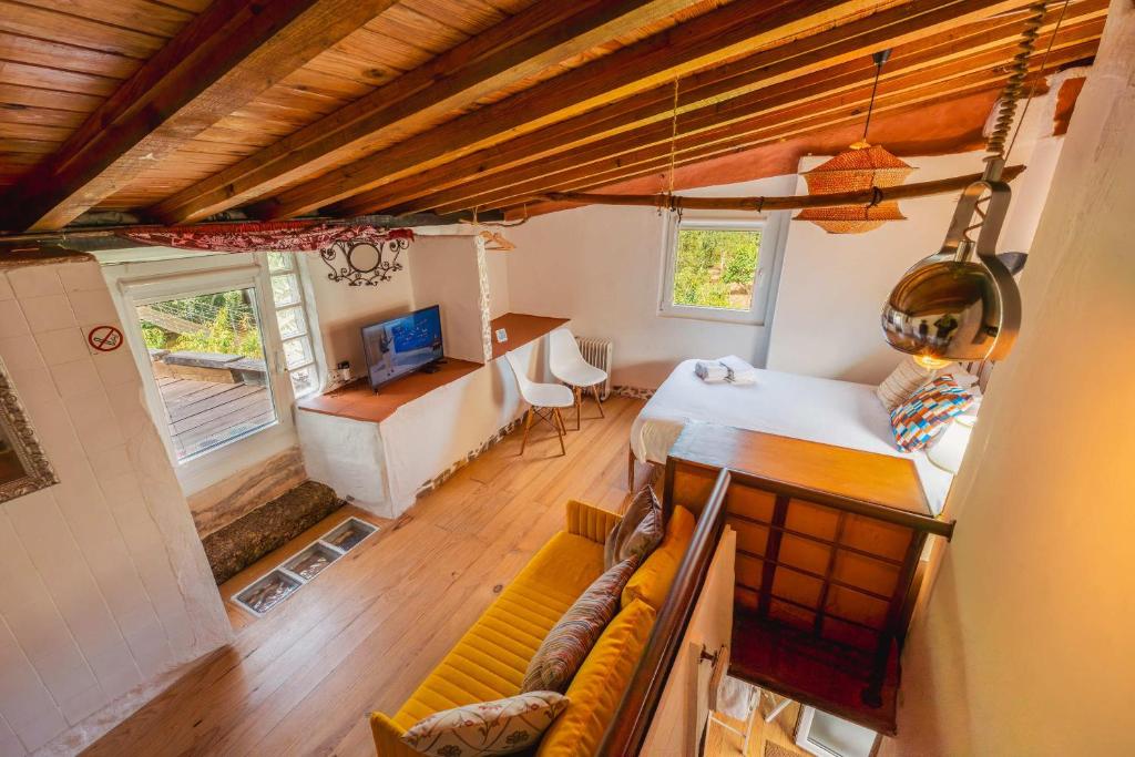 a bedroom with a bed and a couch in a room at Interbeira Sandomil River Cottage in Seia