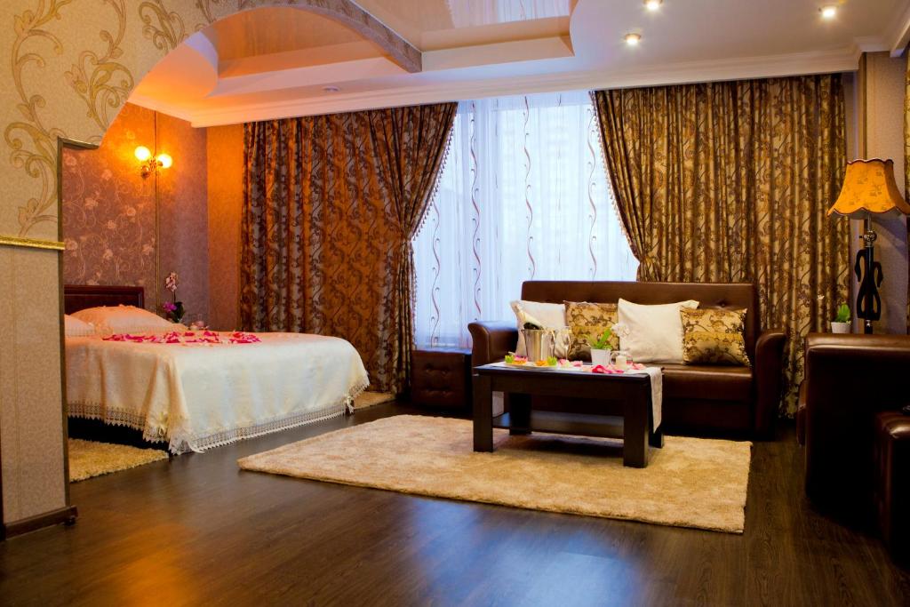1 dormitorio con cama, sofá y mesa en Hotel Yunost en Yekaterinburg