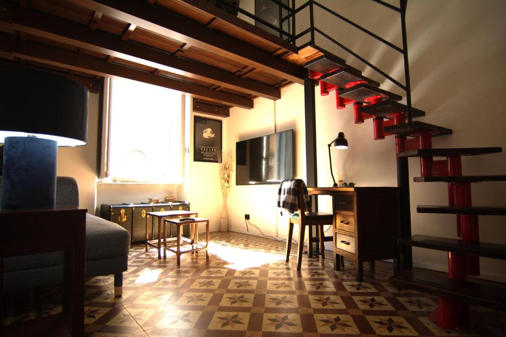 a living room with a staircase and a table and chairs at lovely vintage apartment climatizzato inalpi in Turin