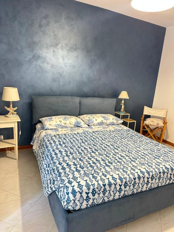 a bedroom with a bed with a blue wall at A due passi dal mare 2023 in Nettuno