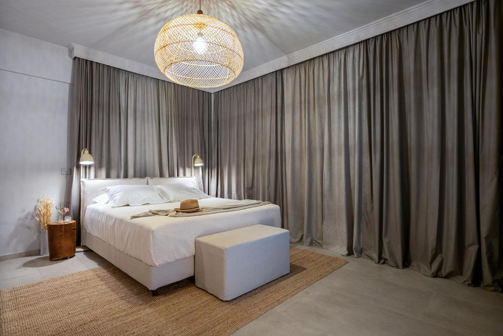 a bedroom with a white bed and a chandelier at Akissare in Kámpos