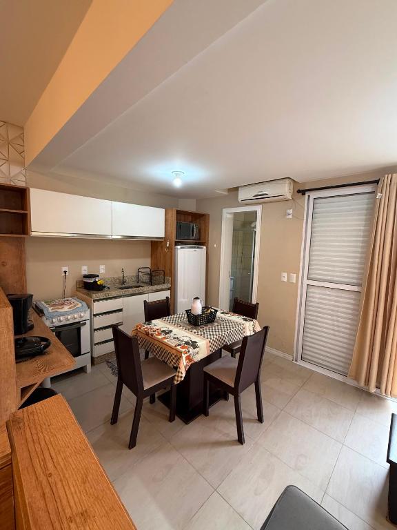 a kitchen with a table and chairs in a room at Loft 102 Farol de Santa Marta in Laguna