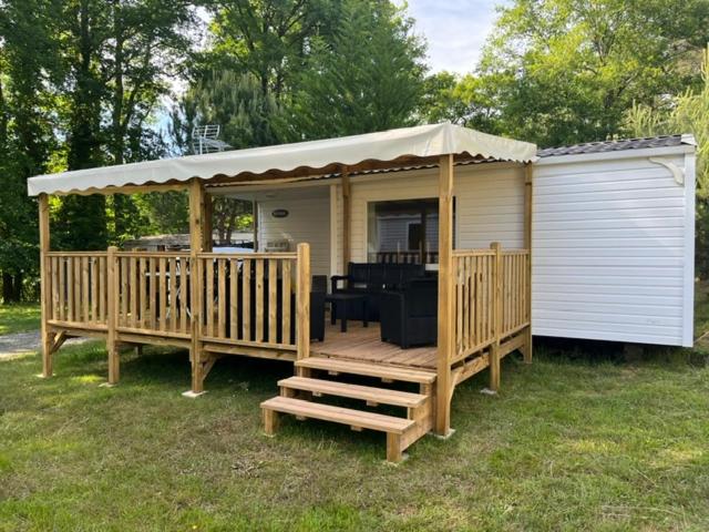 a large wooden deck with a gazebo at camping du Coucou in Nailhac